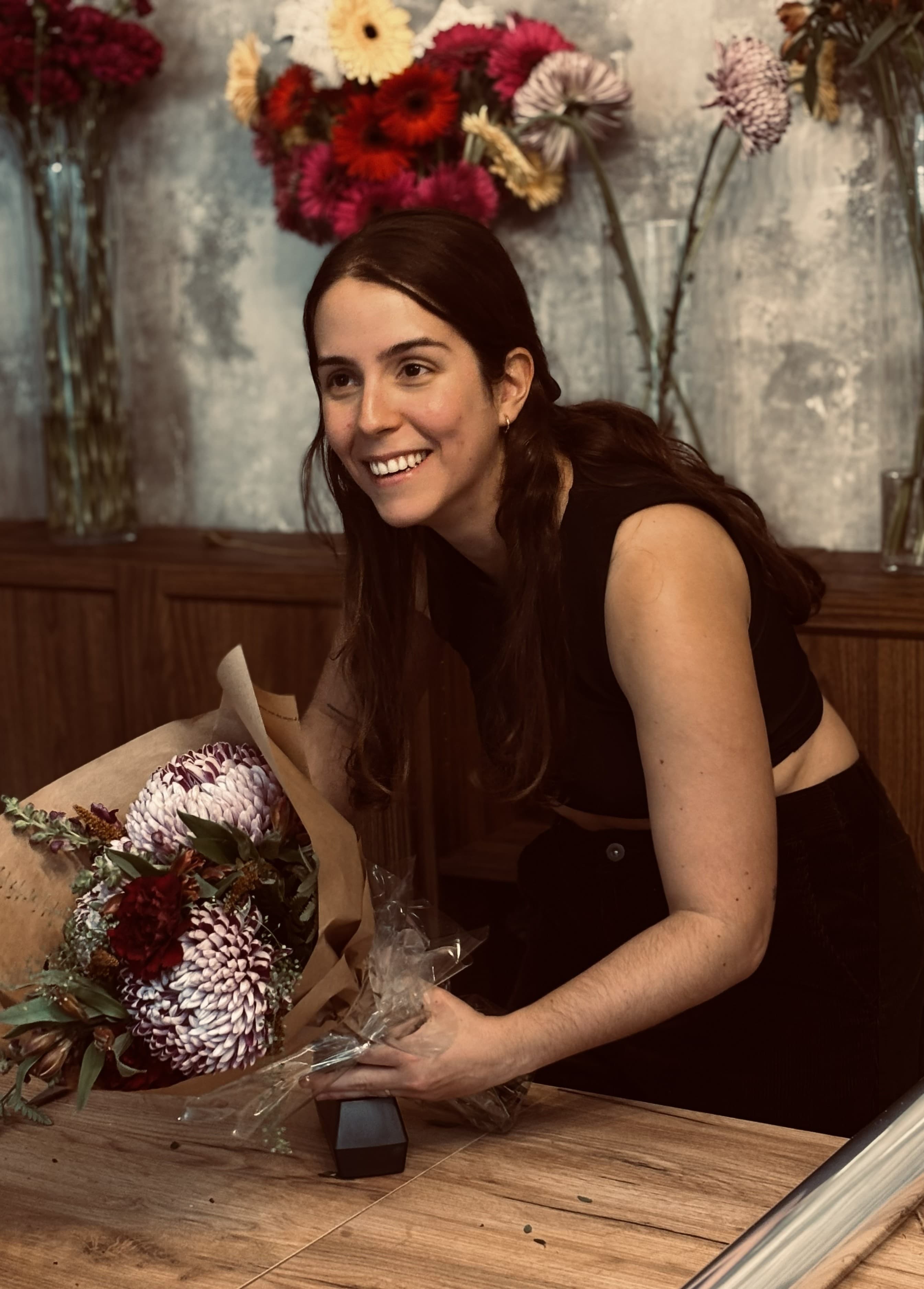 Sofia, founder of Lumea Blooms, with a bouquet of flowers in the workshop, next to the Retreat in Madrid